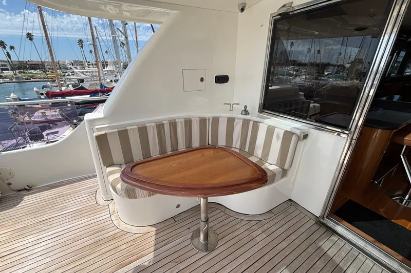 Cozy seating area on 2010 Norseman 80 yacht with striped cushions and wooden table.