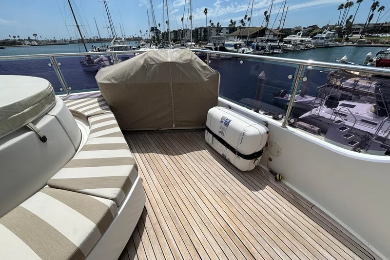 Deck of 2010 Norseman 80 yacht with striped seating and marina view.