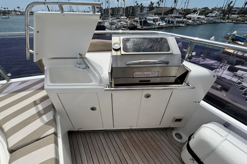 Outdoor kitchen on 2010 Norseman 80 yacht with sink and grill, docked at marina.