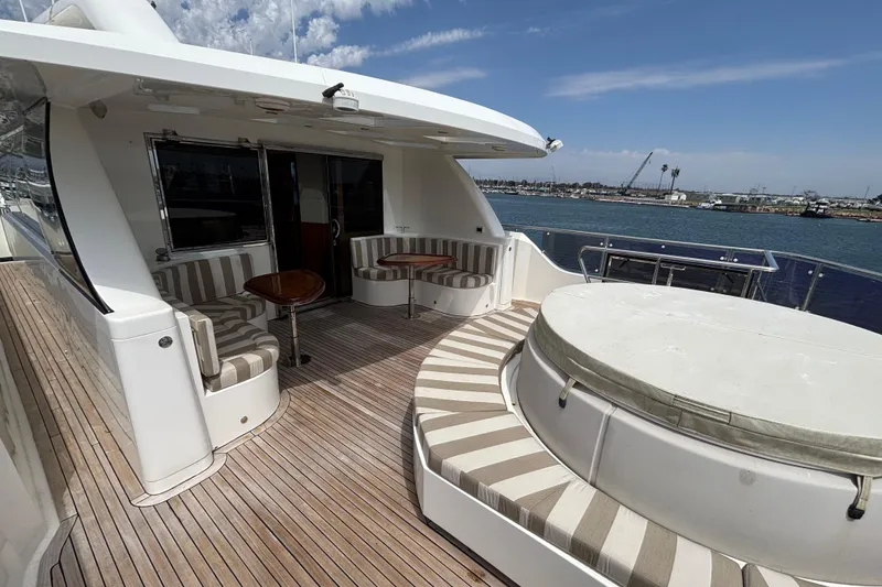 Luxury Norseman 80 yacht deck with seating, 2010 model, overlooking serene waterfront.
