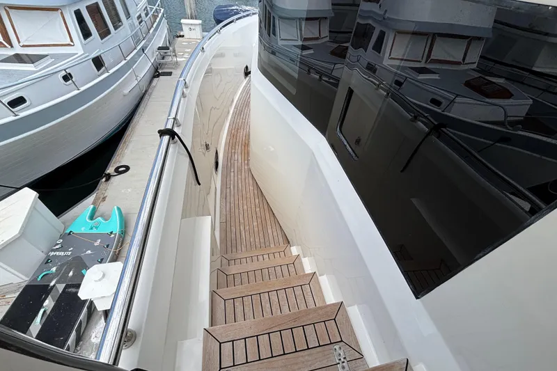 Norseman 80 yacht deck with wooden steps, docked beside other boats, 2010 model.