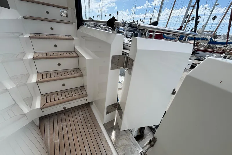 Staircase and open door on a 2010 Norseman 80 yacht, docked at a marina.