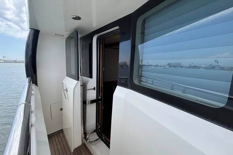 Side deck view of 2010 Norseman 80 yacht with open door and ocean backdrop.