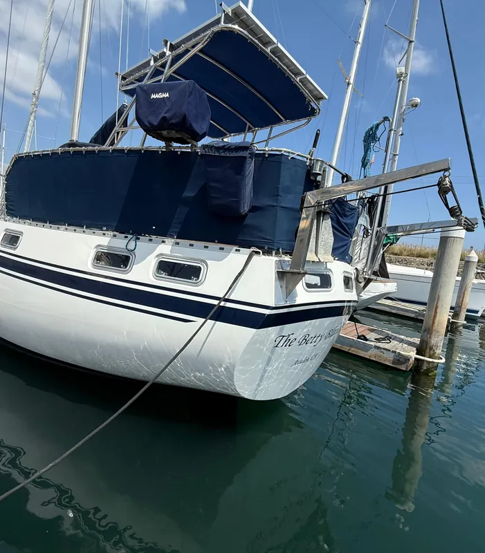 1985 Nauticat 43 sailboat docked, featuring blue canvas covers and stainless steel fittings.