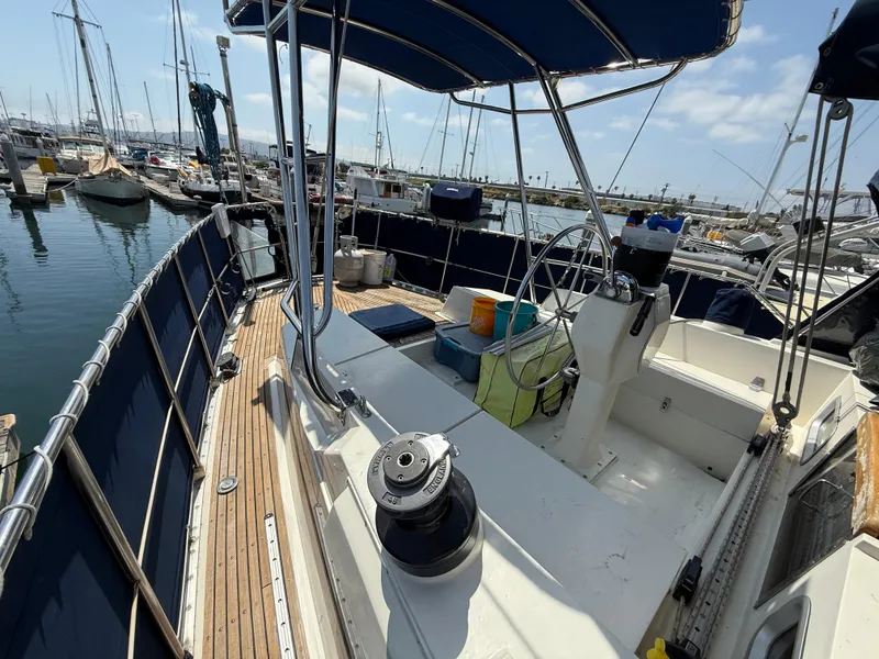 1985 Nauticat 43 sailboat deck with steering wheel, docked in marina.
