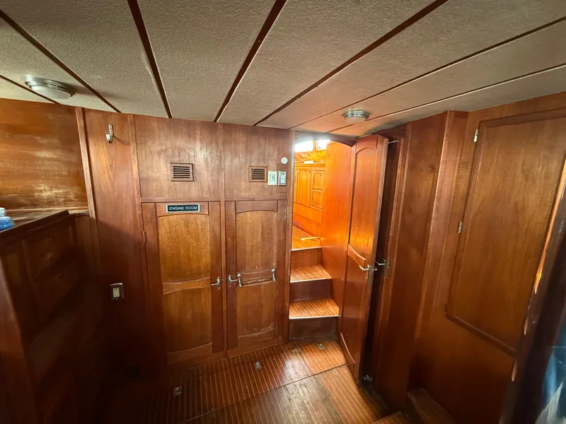 Interior of 1985 Nauticat 43 sailboat, featuring wooden paneling and stairs to upper deck.