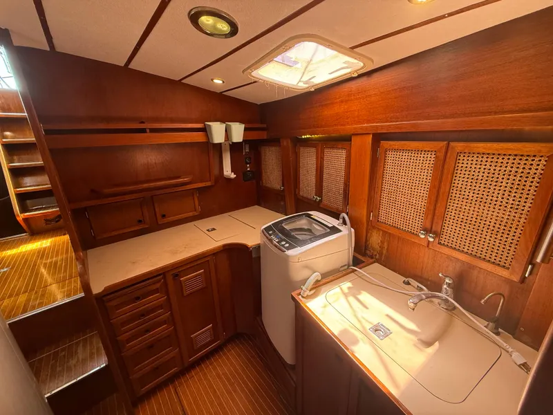 Interior of 1985 Nauticat 43 yacht with wooden cabinetry and washing machine.