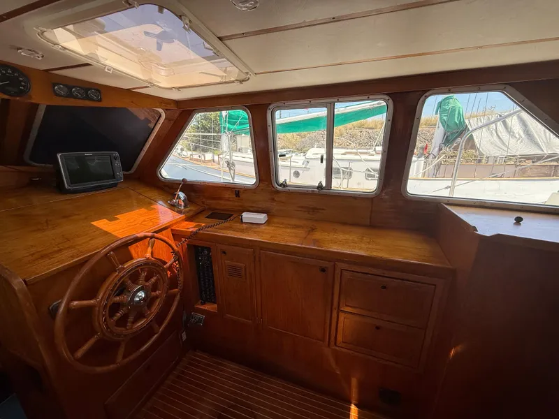 Interior of 1985 Nauticat 43 sailboat with wooden helm and navigation equipment.