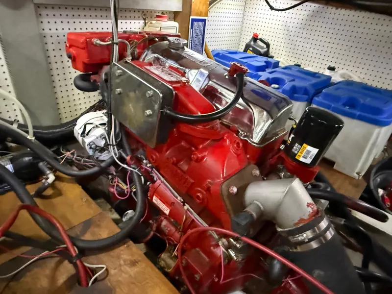Red engine of a 1985 Nauticat 43 sailboat, surrounded by cables and equipment.