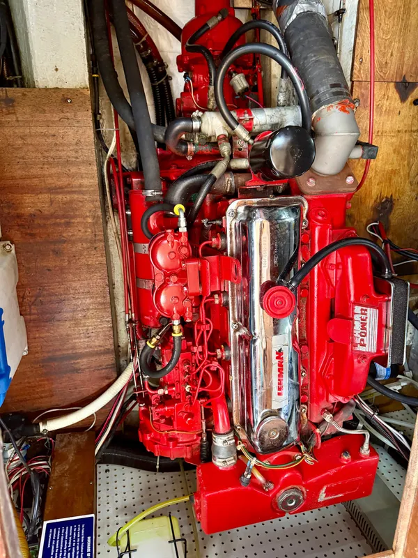 Red engine of a 1985 Nauticat 43 sailboat, showcasing detailed mechanical components.