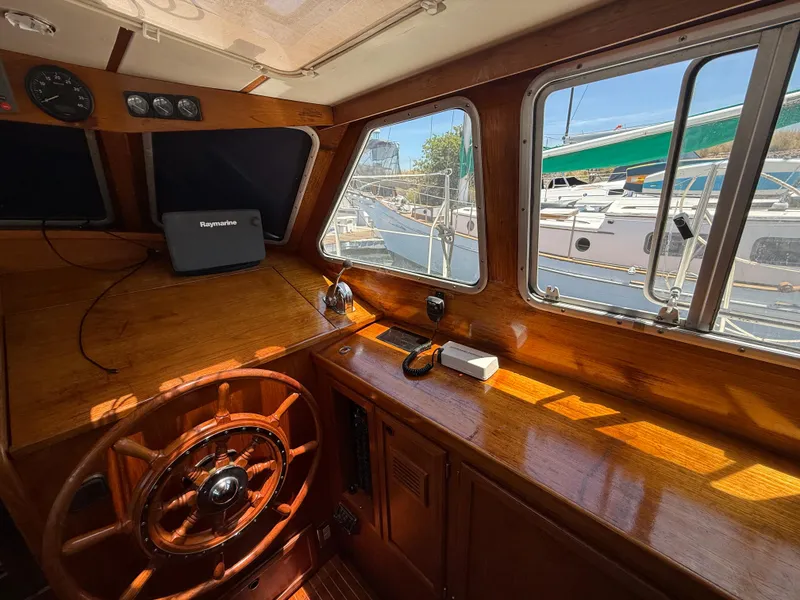 Interior of 1985 Nauticat 43 sailboat with wooden helm and navigation equipment.