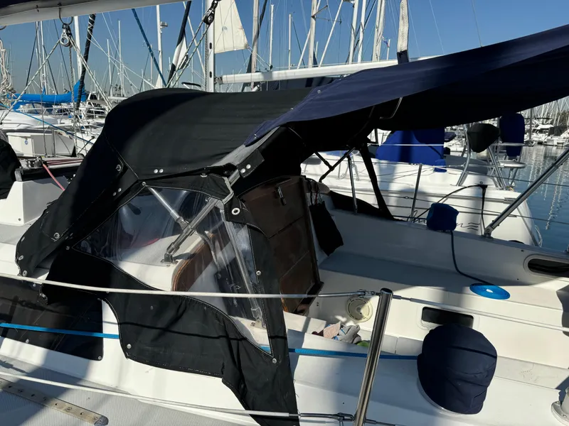 1989 Catalina Sloop sailboat with black canopy docked in marina.