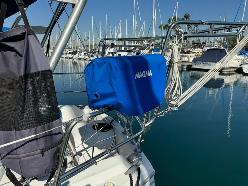 Catalina Sloop 1989 with Magma grill cover in marina, surrounded by sailboats.