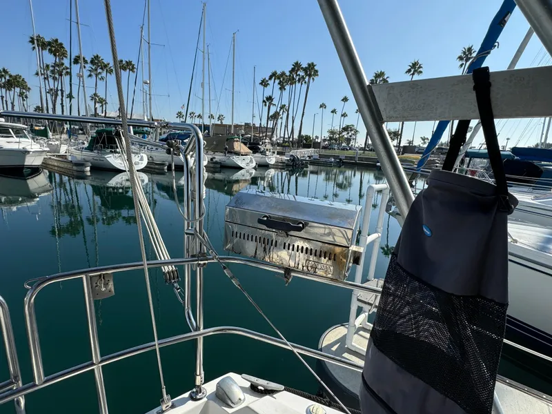 1989 Catalina Sloop in marina, surrounded by sailboats and palm trees, sunny day.