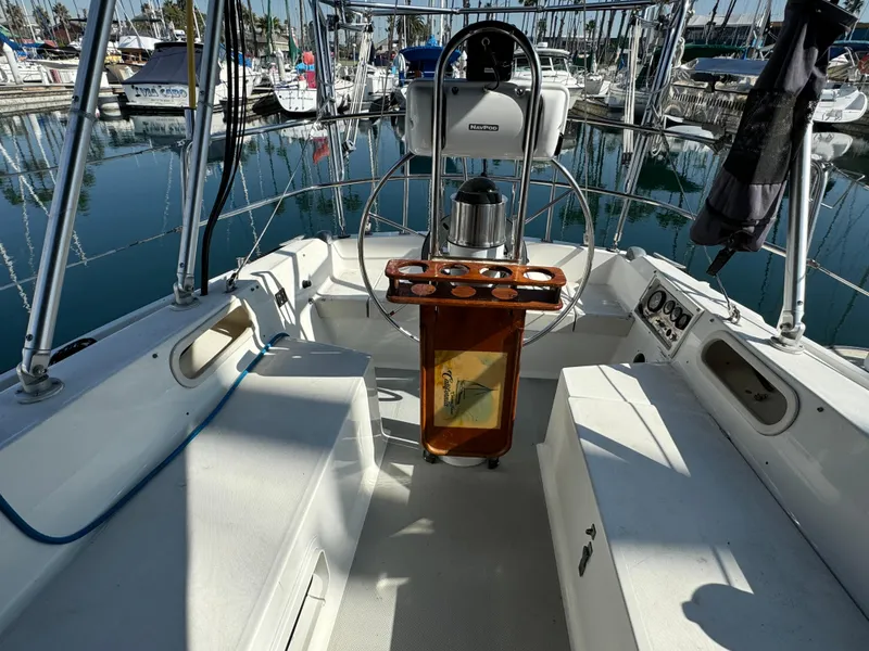 1989 Catalina Sloop cockpit with steering wheel, marina view, and seating area.