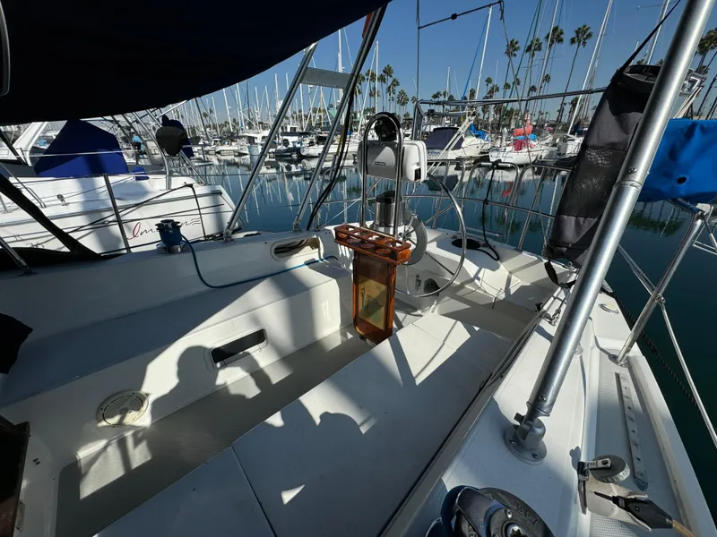 1989 Catalina Sloop sailboat cockpit in marina, surrounded by other boats and clear blue sky.