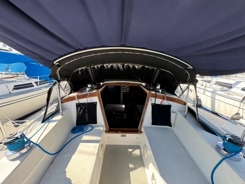 1989 Catalina Sloop sailboat cockpit with blue canopy and seating area.