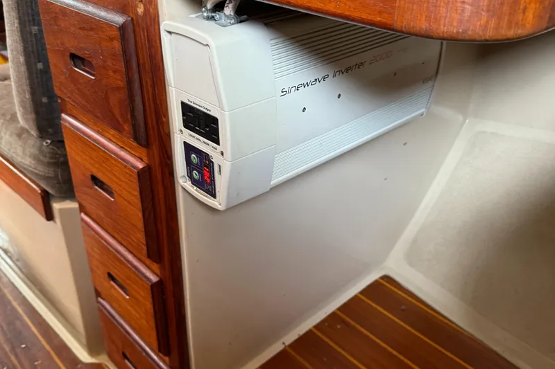 1989 Catalina Sloop interior with sine wave inverter and wooden cabinetry.
