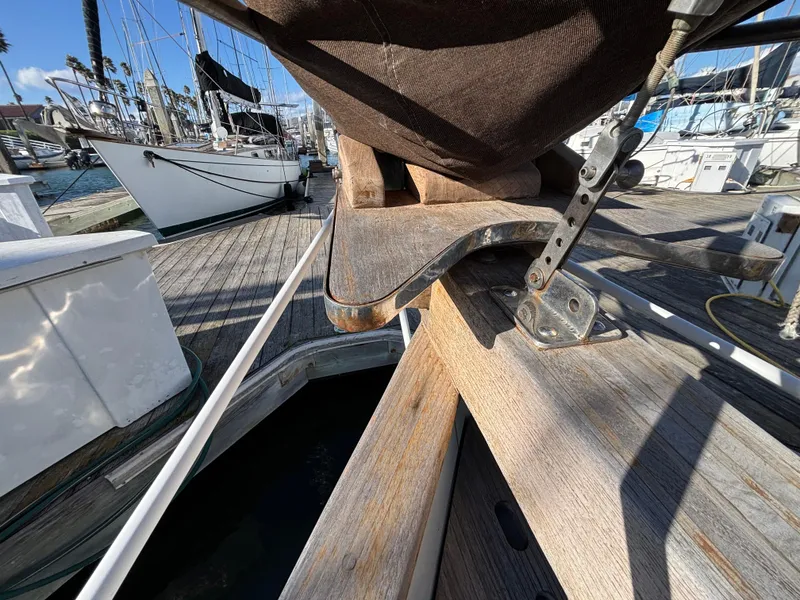 Bow of a 1977 Baba 30 sailboat docked at a marina.