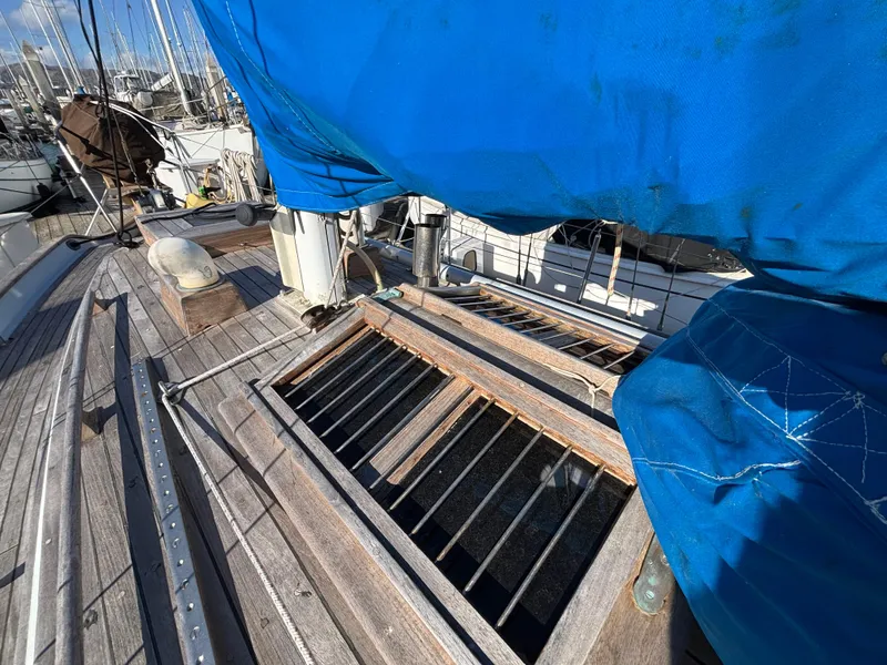 1977 Baba 30 sailboat deck with blue cover and wooden details.