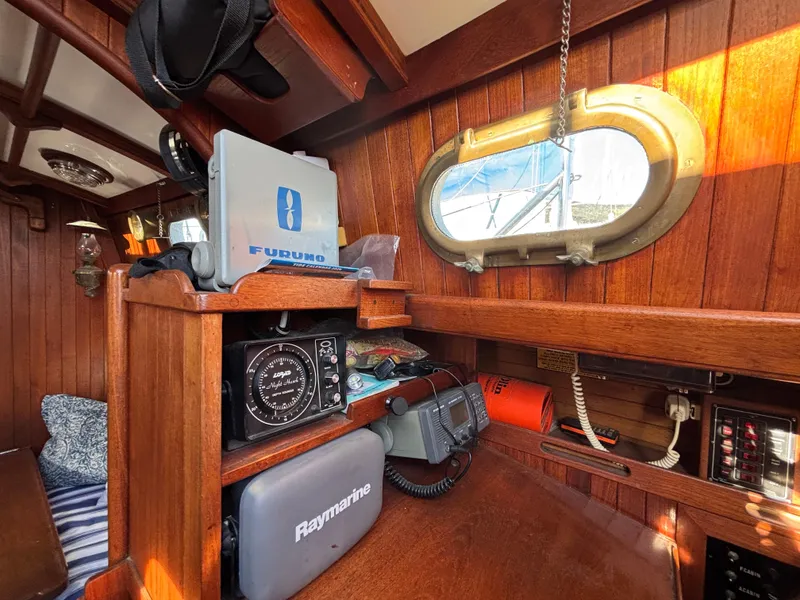 1977 Baba 30 sailboat interior with navigation equipment and wooden paneling.