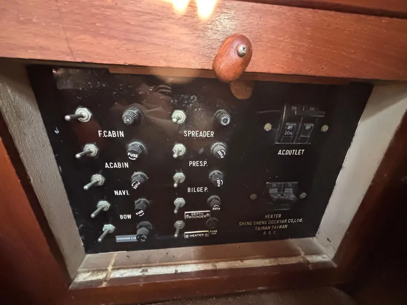 Electrical control panel on a 1977 Baba 30 sailboat with various switches and labels.
