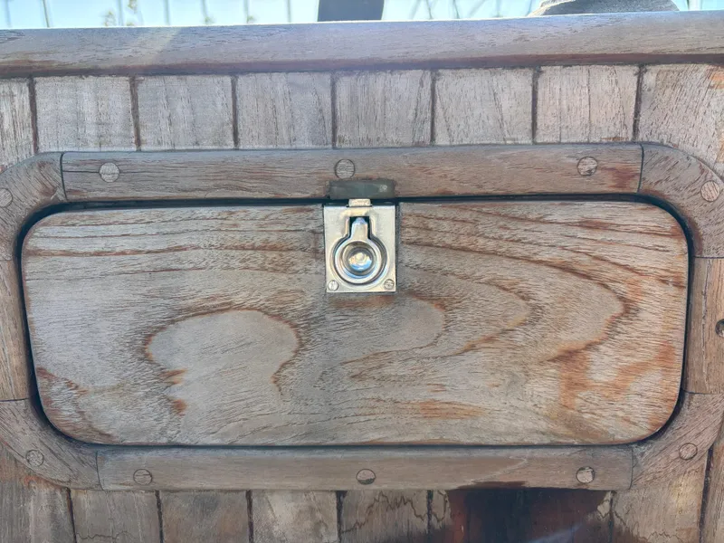 Wooden hatch with metal latch on a 1977 Baba 30 boat.