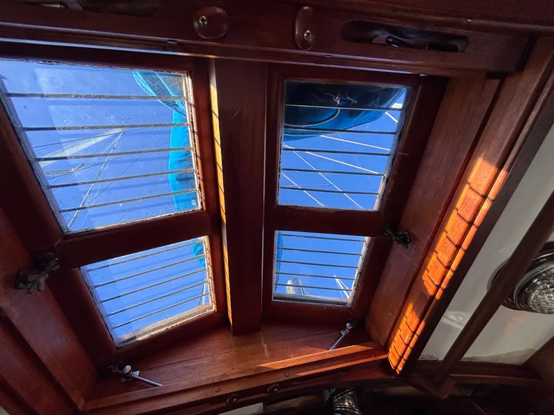 Wooden hatch with metal bars on a 1977 Baba 30 sailboat, view of blue sky.