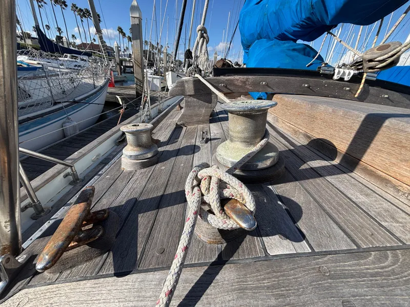 Deck of a 1977 Baba 30 sailboat with winches and ropes in a marina.