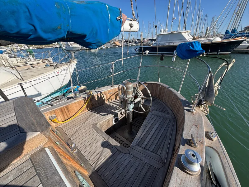 1977 Baba 30 sailboat cockpit with wooden deck, moored in a marina.