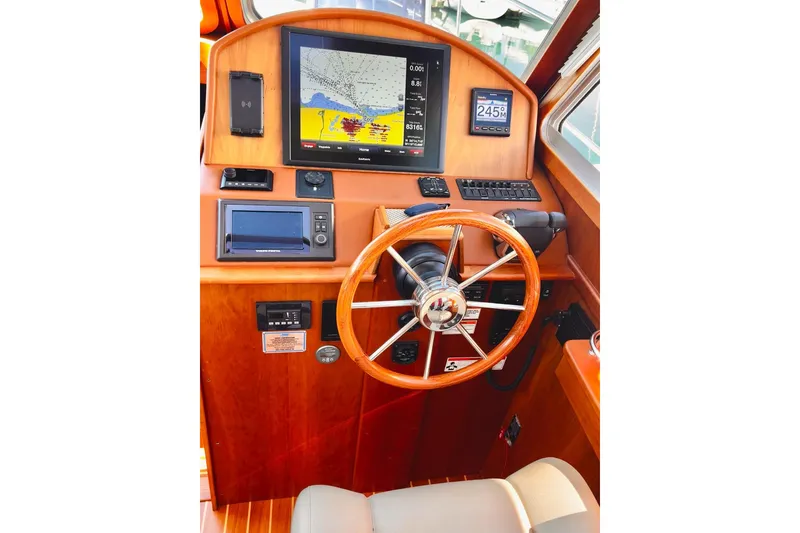 Helm of 2016 Sabre 38 Salon Express with navigation equipment and wooden steering wheel.