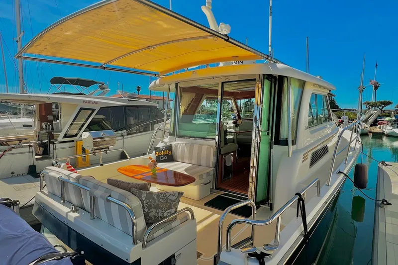 2016 Sabre 38 Salon Express yacht docked, featuring a spacious outdoor seating area under a canopy.