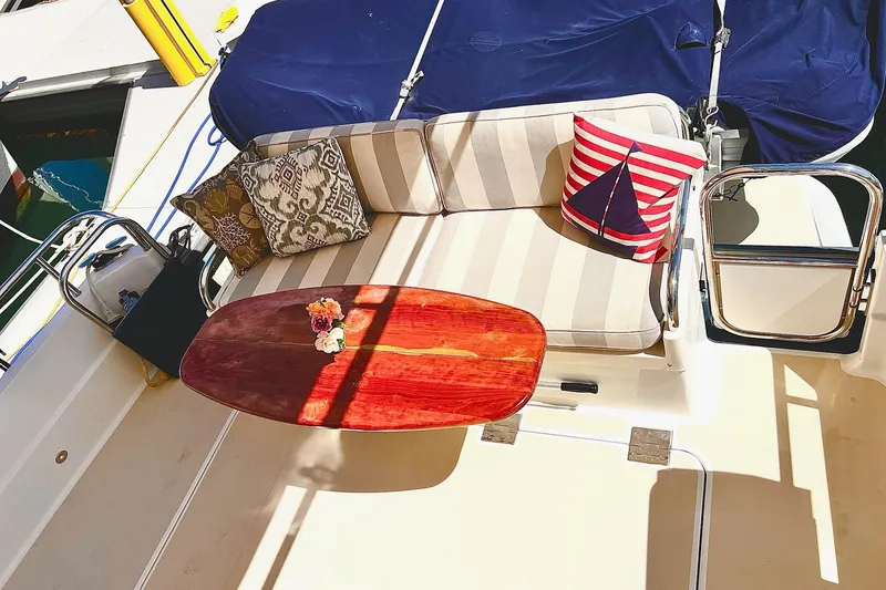 Cozy seating area on 2016 Sabre 38 Salon Express yacht with decorative pillows and wooden table.