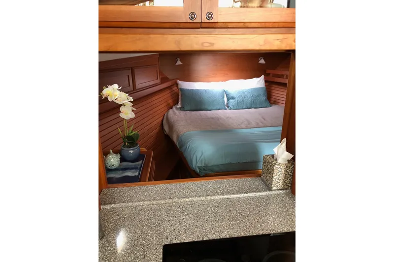 Cozy bedroom interior of 2016 Sabre 38 Salon Express yacht with elegant wood finish.