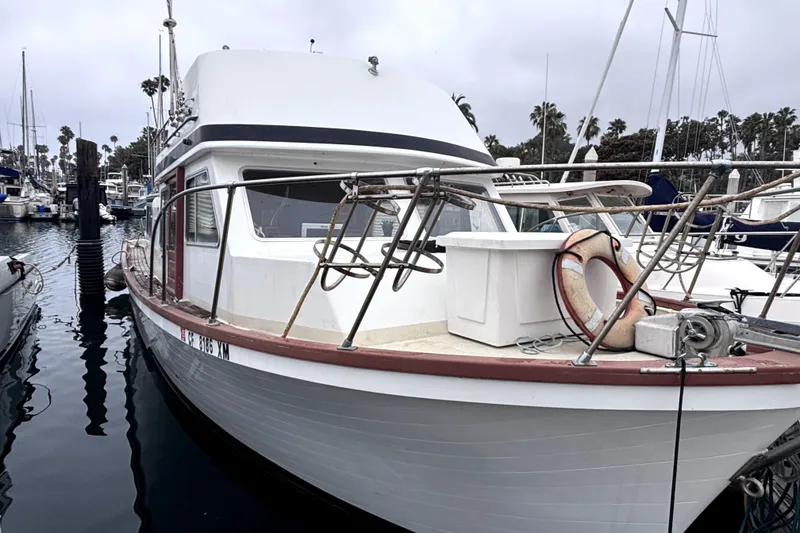 1974 Skookum 34 boat docked in marina, featuring classic design and life preserver.