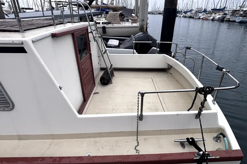 1974 Skookum 34 boat docked at marina, featuring spacious deck and railing.