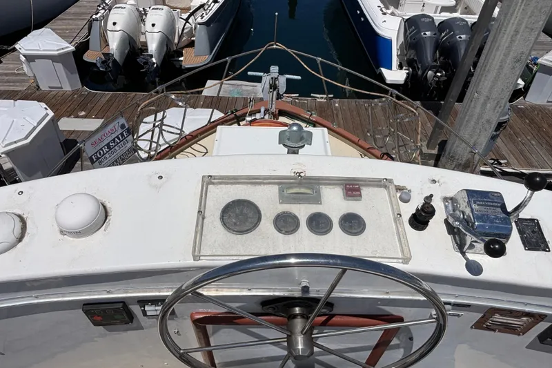 1974 Skookum 34 boat dashboard with steering wheel and control panel at marina.