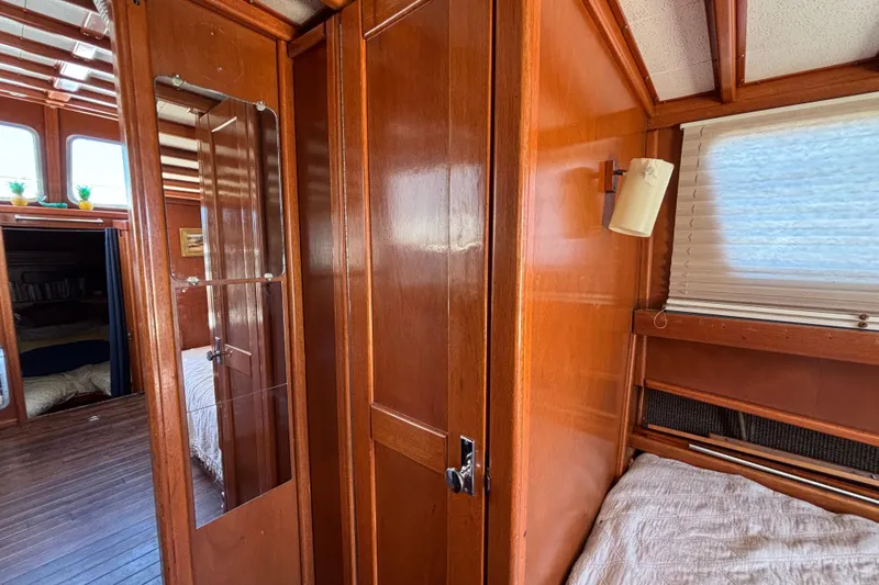 Interior of a 1974 Skookum 34 boat with wooden paneling and cozy sleeping area.