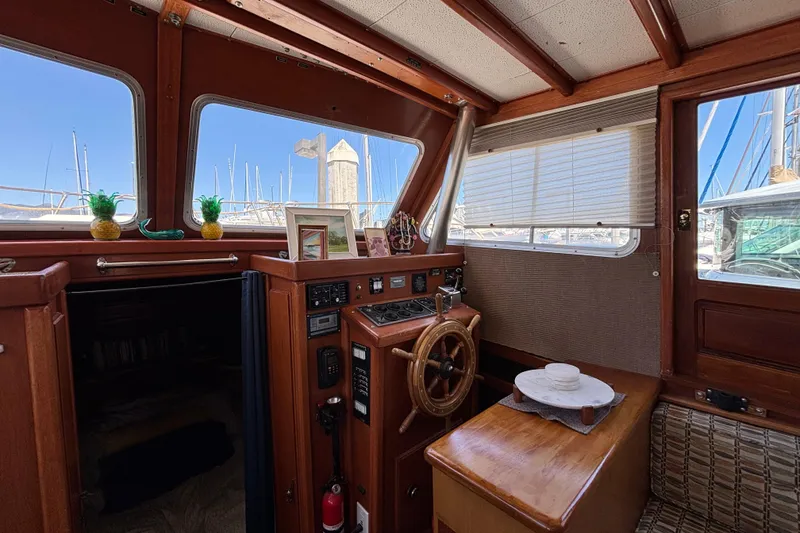 Interior of a 1974 Skookum 34 boat with wooden helm and nautical decor.
