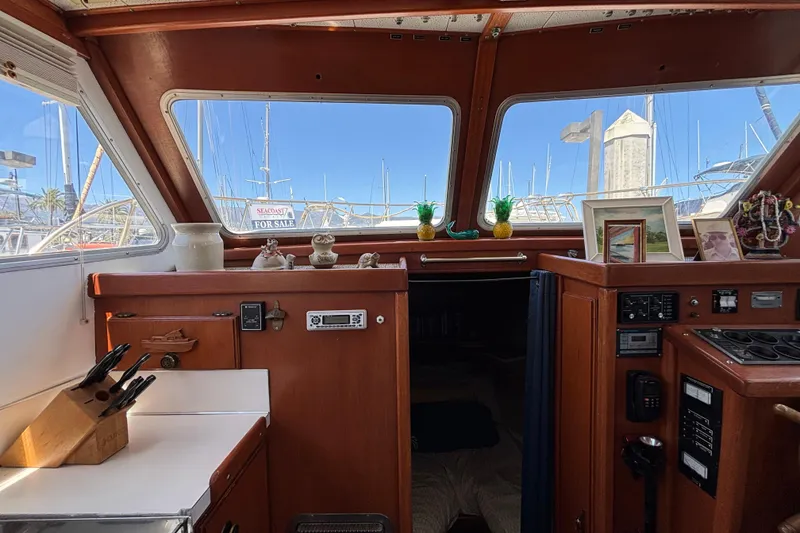 Interior of a 1974 Skookum 34 boat with wooden cabinetry and nautical decor.