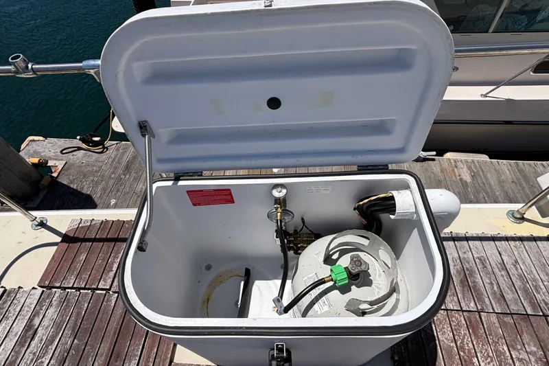 Open storage compartment on a 1974 Skookum 34 boat, revealing a propane tank.