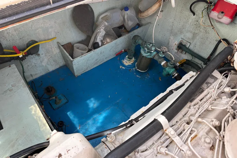 Engine compartment of a 1974 Skookum 34 boat, featuring mechanical components and storage.
