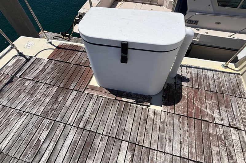 Wooden deck on a 1974 Skookum 34 boat with a white storage box.