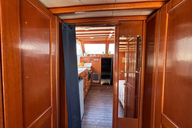 Interior of a 1974 Skookum 34 boat with wooden paneling and cozy cabin space.