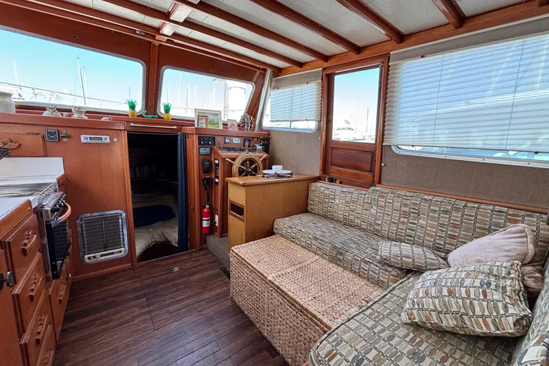 Interior of a 1974 Skookum 34 boat with cozy seating and wooden accents.