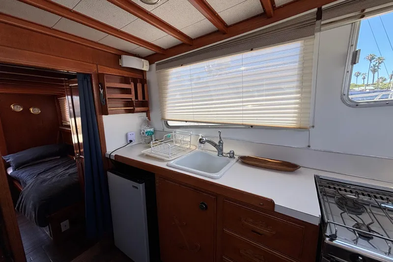 1974 Skookum 34 boat interior with kitchenette, sink, and cozy sleeping area.