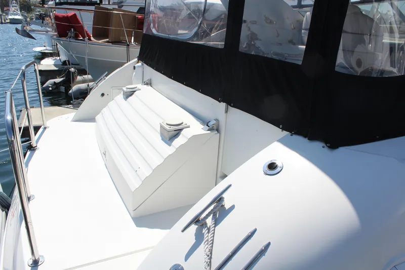 1996 Trojan 440 Express yacht deck with seating and railing, docked at marina.