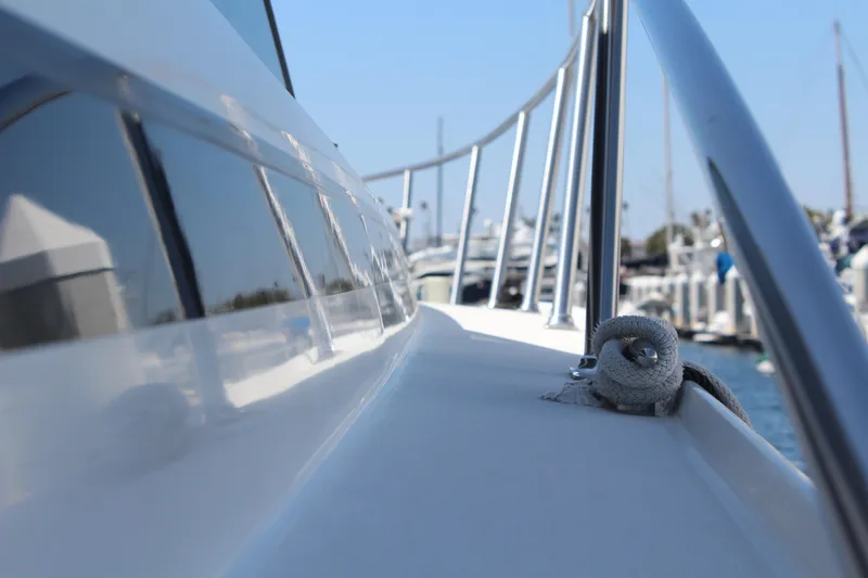 Close-up of a 1996 Trojan 440 Express yacht railing and deck, docked at a marina.