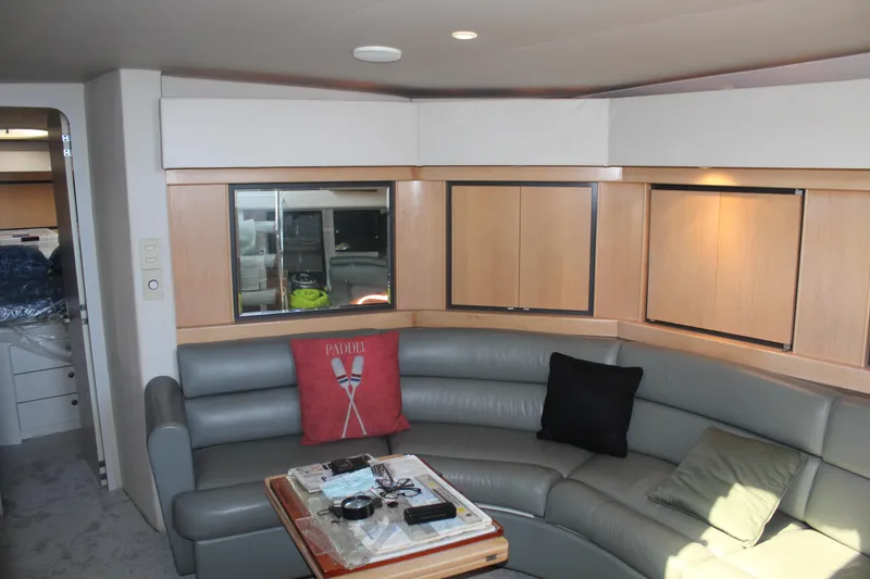 Interior of 1996 Trojan 440 Express yacht with curved seating and wooden cabinetry.