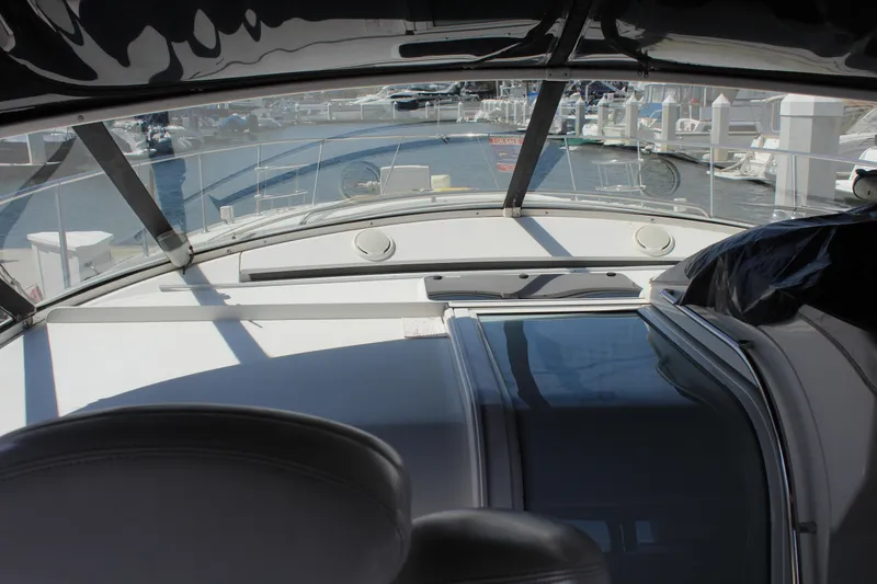 1996 Trojan 440 Express yacht interior with marina view through windshield.